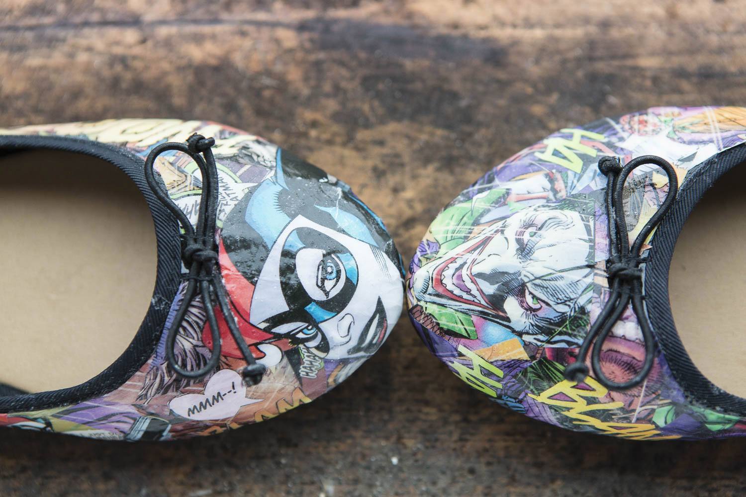 A close-up of the bride's customized wedding shoes adorned with comic book pages.