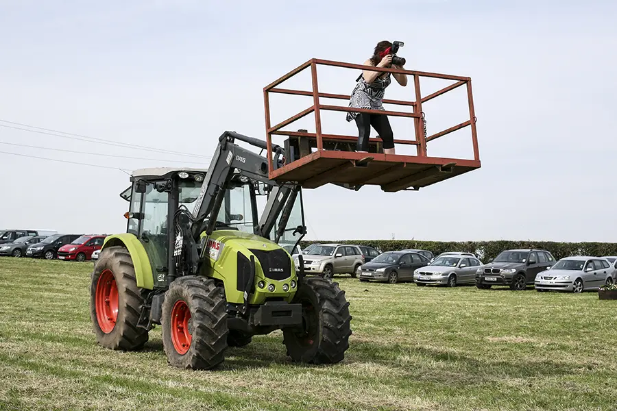 Photograph of Charlene in an elevated tractor bucket doing anything to get the shot